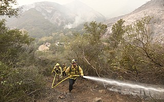 Garth White, with a crew from Bend Oregon City firefighters, works a hose alongside members of Arroyo Grande Hotshots, Santa Lucia Crew Seven and Vandenberg Hotshots working to cut a fire break up steep terrain in Toro Canyon. (Dec. 12, 2017)