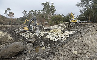 Heavy machinery works to break down and truck out boulders from the Cold Spring Creek debris basin. (Jan. 19, 2018)