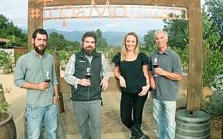 The Topa Mountain team—from left, cellar master Alex Tombelli, winemaker Dominic O'Reilly, tasting room manager Jackie Franklin, and owner Larry Guerra—stands at the best place to spot Ojai's sunset shade of pink.