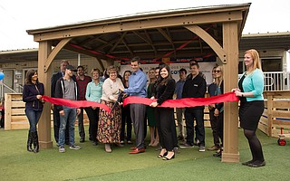 A cohort from Leadership Santa Barbara and Lori Goodman, executive director of the Isla Vista Youth Projects (pictured center-left), cut the ribbon in front of a new gazebo at the Isla Vista Youth Projects Children's Center.
