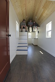 Dos Pueblos students (from left) Finn McKenna, Maclane “Mac” Diehl, and Zack Tedeschi sit inside the tiny home that their class has been working on for more than two years.