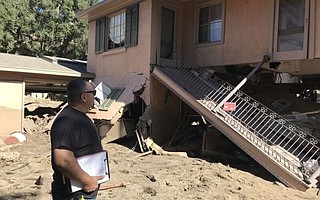 Rudy Raygoza inspects a red-tagged home near East Mountain Drive.