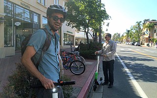 Santa Barbara Bicycle Coalition Executive Director Ed France (left) and City Councilmember Jason Dominguez try checkout Limebike scooters on State Street
