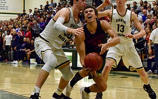 Santa Barbara High’s Bryce Warrecker (left), with help from teammate Aiden Douglas (13), puts the clamps on San Marcos star Beau Allen.