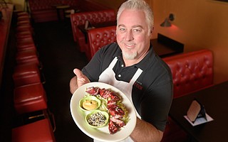 Three Pickles's owner Clay Lovejoy shows off a Jimmy’s special Tommy's Famous Sliced BBQ Pork which is on the menu for a limited time during the start of the Chinese Year of the Pig.