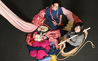 Artist Tamika Rivera (left) and S.B. Centre for Aerial Dance’s Ninette Paloma sit in a pile of yarn below an aerial silk, both main ingredients in <em>Haven</em>.