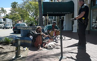 Officer Brian Kerr speaks with Johnathon Lowry and Tyrone Marsaw following complaints of marijuana odors on State Street.