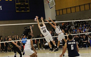 Louis Richard hits into the block of Casey McGarry and Brandon Hicks.