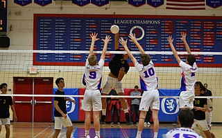 Will Rottman hits through the outstretched arms of Cade McLean and Toby Still